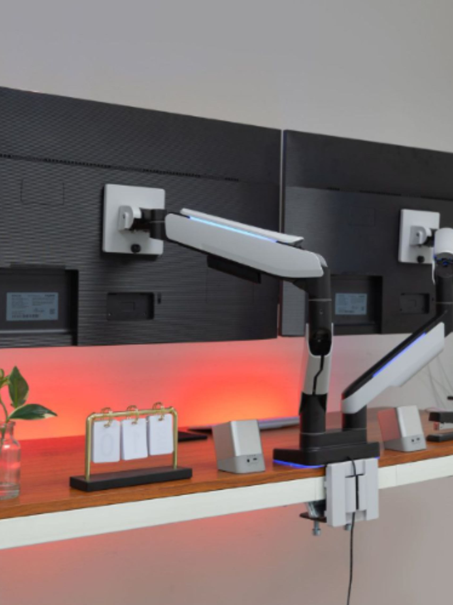 Dual monitor arm mount on a home office desk with RGB bias lighting and USB hub for ergonomic setup
