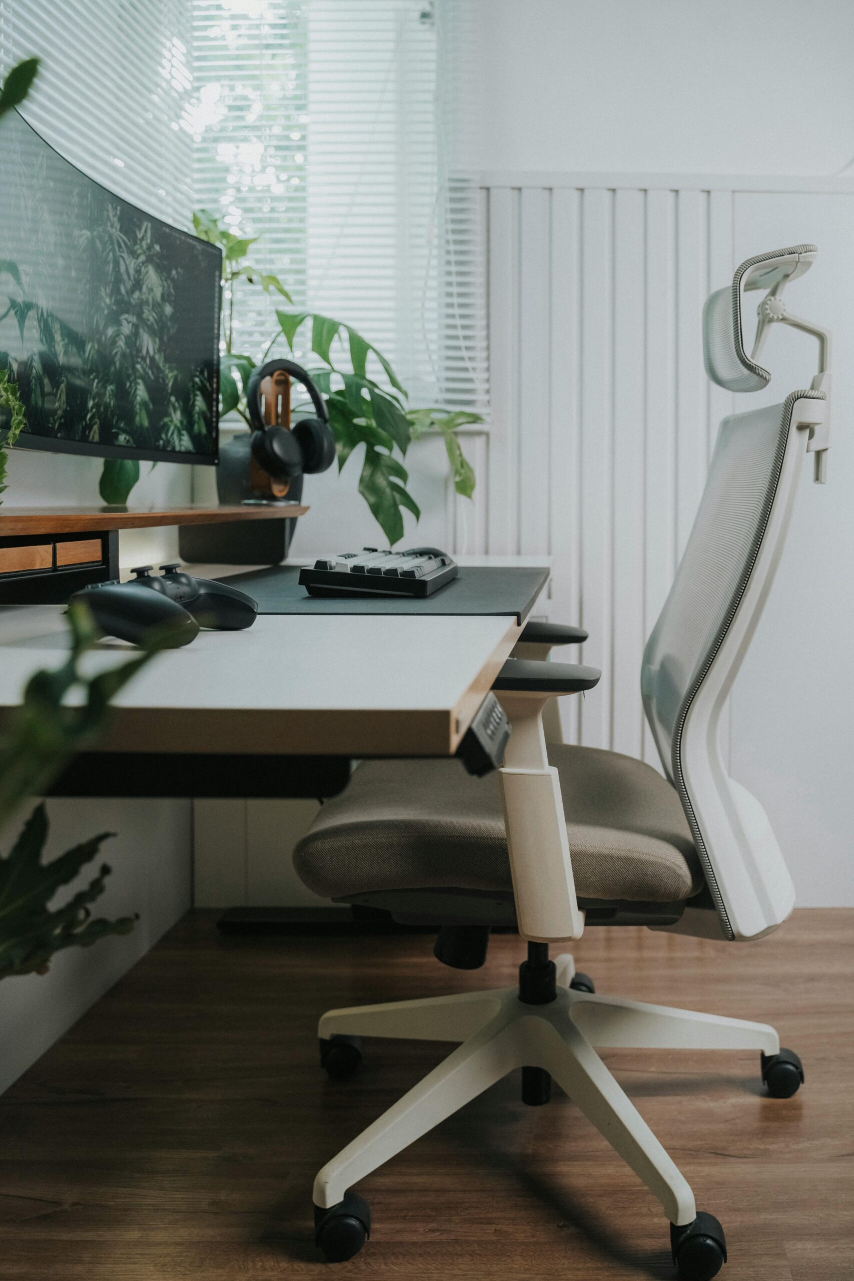 Ergonomic home office setup with high-back mesh chair, standing desk, curved ultrawide monitor, and mechanical keyboard for remote work